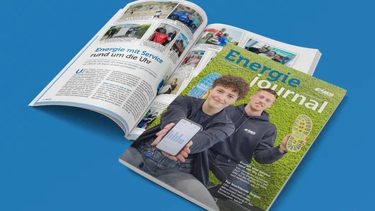 Ein geschlossenes Exemplar des Energiejournals Dezember 2025 liegt über einem aufgeschlagenen Exemplar