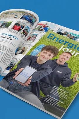 Ein geschlossenes Exemplar des Energiejournals Dezember 2025 liegt über einem aufgeschlagenen Exemplar