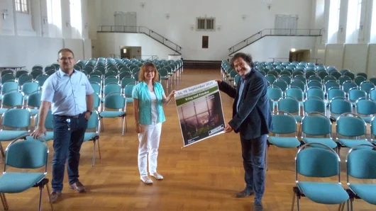 Jana Reifarth vom Schloss-Förderverein präsentiert gemeinsam mit dem Chefdirigenten der Mitteldeutschen Kammerphilharmonie Jan Michael Horstmann das Konzertplakat.