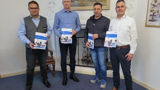 Der Bericht zur Kommunalen Wärmeplanung für die Stadt Zerbst / Anhalt liegt in gedruckter Form vor – von links Frank Sieweck (EMS), Bürgermeister Andreas Dittmann, Markus Pfeifer (Amtsleiter Zentrale Dienste Stadt Zerbst/Anhalt) und Dirk Bischoff (EMS). 